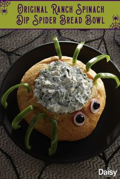 a spider bread bowl with spinach dip in the middle and eyes on it's side