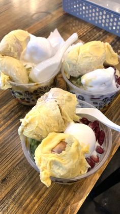 three plastic bowls filled with food on top of a wooden table