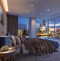 a bedroom with a view of the city at night