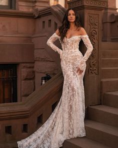 a woman in a wedding dress standing on some steps with her hands on her hips