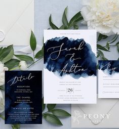 wedding stationery with blue watercolor paint and white peonies on the table