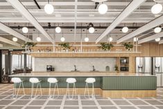 an open kitchen with lots of counter space and hanging lights above the bar area, along with four white stools