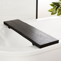 a bath tub with a wooden shelf on the side