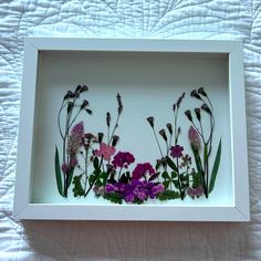 a white frame with purple and pink flowers in it