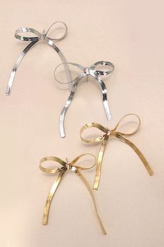 three different types of bows tied together on a white surface with gold and silver ribbons