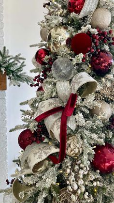 a decorated christmas tree with red, white and silver ornaments on it's branches