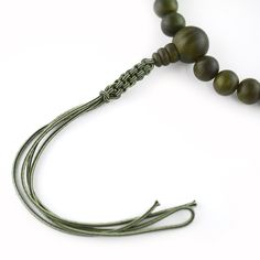 Green Lignum Vitae Wood Juzu Prayer beads Materials : Lignum vitae wood, Silk cord Diameter : about 10cm (not elastic) Head bead : about 16mm Main beads : about 11mm Handmade in Kyoto, JAPAN Lignum vitae wood is said to be the densest wood in the world, grows extremely slowly, and extremely rare, so it is called a "wooden jewel" and is prized.It has the characteristic of changing to a deeper green color over time. It has been treated like a jewel, since ancient times It was only allowed to have by aristocrats. In Japan, Buddhists have Prayer beads (Juzu, Nenju). Kyoto is famous as a producing center of Prayer beads. Prayer beads are a traditional tool used to count the number of times a mantra is recited, breaths while meditating, counting prostrations, or the repetitions of a buddha's nam Adjustable Wooden Beaded Bracelet With 8mm Beads, Adjustable Wooden Beaded Bracelets With 8mm Beads, Adjustable Green Wooden Beads, Adjustable Wooden Beaded Bracelets For Meditation, Wooden Round Beads Jewelry For Meditation, Adjustable Wooden Beads, Lignum Vitae, Kumihimo Bracelets, Traditional Ceramics