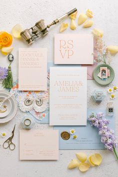 the wedding stationery is laid out on top of each other with flowers and scissors