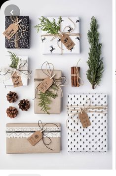 christmas presents wrapped in brown paper and tied with twine, pine cones, cinnamon sticks, evergreen branches, and tags