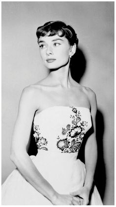 a black and white photo of a woman in a strapless dress with flowers on it