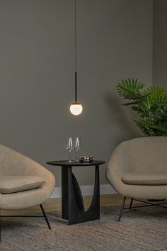 two chairs sitting next to each other in front of a table with wine glasses on it