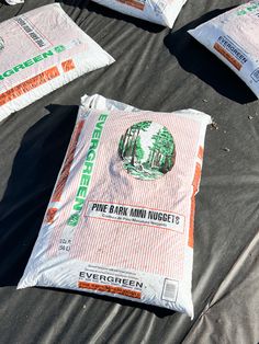 bags of evergreen pine bark and mulchs are laid out on the tarp