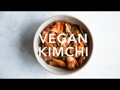 a white bowl filled with vegetables and the words vegan kimchi on top of it