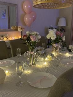 a dining room table is set with plates, glasses and candles for an elegant dinner