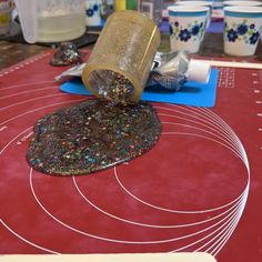 a table topped with lots of crafting supplies on top of a red counter covered in confetti