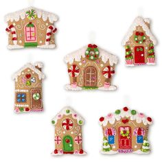 four gingerbread houses are decorated with candy canes