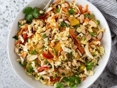 a white bowl filled with rice and veggies on top of a gray table