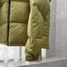 Embrace the spirit of outdoor adventure with this retro-inspired puffer jacket. This stylish jacket, reminiscent of The North Face 1996 Retro Nuptse, features a unique color-blocked design with a light olive green body and contrasting black shoulder panels. The boxy silhouette and oversized baffles offer a classic 90s vibe, while the high-quality down-filling ensures exceptional warmth and comfort. Whether exploring the city or venturing into the wilderness, this jacket perfectly blends style an Puffer Jacket With Padded Collar For Outdoor Activities, Sporty Green Outerwear For Winter, Casual Outdoor Puffer Jacket With Padded Collar, Solid Windproof Puffer Jacket For Outdoor, Casual Green Puffer Jacket For Hiking, Down Puffer Jacket For Outdoor Activities, Green Duck Down Outerwear For Fall, Duck Down Puffer Jacket With Pockets For Outdoors, Urban Puffer Jacket For Outdoor