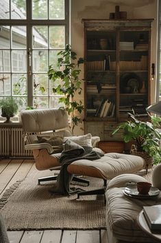 a living room filled with furniture and lots of windows next to a bookshelf