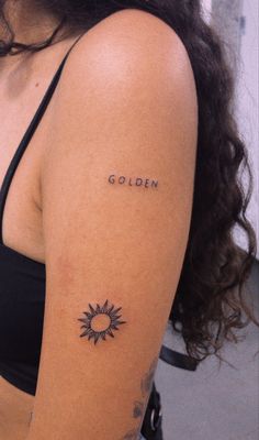 a woman's arm with the word golden tattooed on her left shoulder and sun in the middle