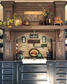 an old fashioned kitchen with lots of cupboards and pots on the top shelf above the stove