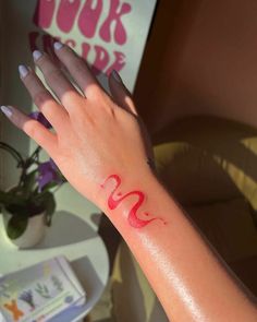 a woman's hand with red ink on it and the word love painted on her wrist