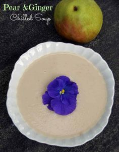 pear and ginger chilled soup in a white bowl with a purple flower on the rim