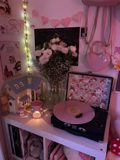 a record player sitting on top of a table next to a vase filled with flowers