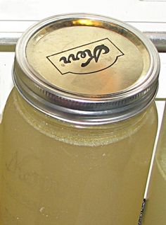 a mason jar filled with liquid sitting on top of a window sill next to a door