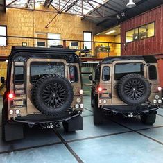 two jeeps parked in a garage with their doors open