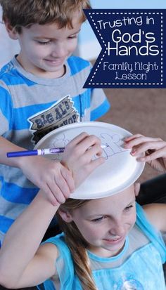 two young children are playing with paper plates and writing on the plate that says, trusting god's hands family night lesson