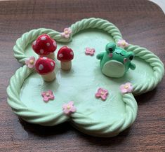 there is a cake that looks like mushrooms on the plate and frog in the middle