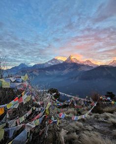 there are many colorful flags on the mountain side with mountains in the backgroud