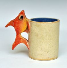 a ceramic mug with a fish shaped handle