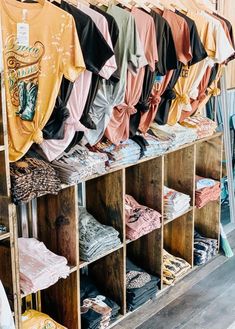 shirts are hanging on the clothes rack in a store