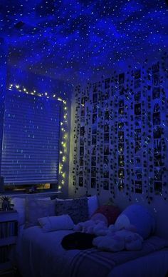 a bedroom with blue lights on the ceiling and stars in the ceiling above the bed