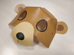 a brown paper bear mask sitting on top of a table