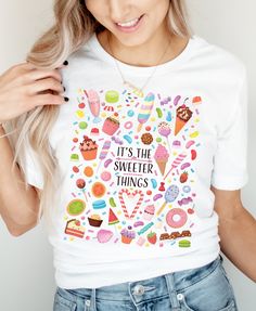 This sweet Summer tee has all the little things! Sweet strawberries, cupcakes, popsicles, and lollypops and chocolates! Find your favorite sweet delight! Designed with love at home, then made to order and shipped by a professional printing company! This t-shirt is everything you've dreamed of and more. It feels soft and lightweight, with the right amount of stretch. It's comfortable and flattering for all.  * 100% combed and ring-spun cotton (Heather colors contain polyester) * Fabric weight: 4. White Sweet T-shirt With Funny Print, Sweet White T-shirt With Funny Print, Sweet Summer Tops As Gift, Sweet Summer Tops For Gift, Cute Funny Print T-shirt, Sweet Summer T-shirt As Gift, Sweet T-shirt For Summer Gift, Summer Sweets, Strawberry Shirt