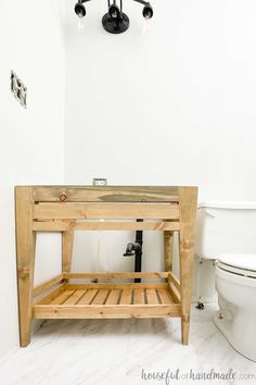 a bathroom with a toilet, sink and wooden shelf next to the bathtub in it