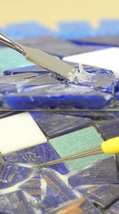 a pair of scissors sitting on top of a blue and white mosaic tile countertop