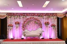 the stage is decorated with flowers and white furniture