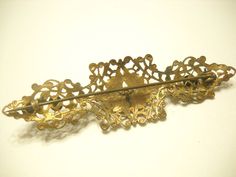 "Vintage 1940s Art Deco gold tone brooch. 3 1/4\" x 1\". Very ornate, intricately designed gold tone metal brooch. Five brightly colored discs (probably foil back) inserted on the front. Fastener does not have a spring clasp....just fastens into a \"C\" hook. This is in excellent condition. Unsigned." Ornate Bronze Brooch Jewelry, Vintage Gold Brass Brooches, 1940s Art Deco, Art Nouveau Yellow Gold Brooch, 1940s Art, Art Nouveau Yellow Gold Collectible Brooches, Cowrie Shell Necklace, Metal Brooch, Art Deco Gold