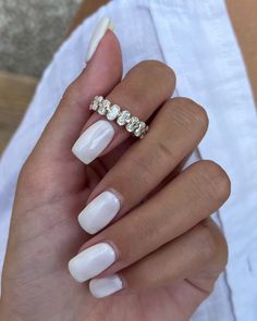 a woman's hand with white manies and a diamond ring