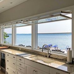 a kitchen with large windows overlooking the ocean