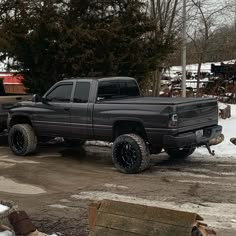 a black truck parked on top of a snow covered field