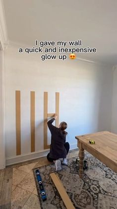 a person sitting on the floor in front of a wall with some tape taped to it