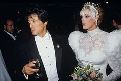 a man in a tuxedo standing next to a woman wearing a white dress