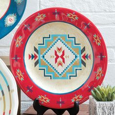 three plates sitting on top of a wooden table next to a potted succulent