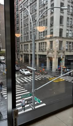 an empty city street is seen through a window