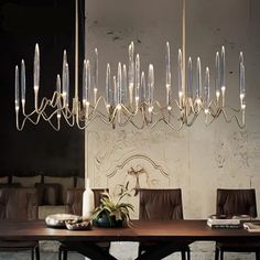 an elegant chandelier hangs over a dining room table